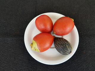 Fruits of Cyrtostachys renda, also known by the common names red sealing wax palm and lipstick palm...