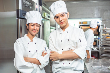 Couple asian young female bakers looking at camera..Chefs  baker in a chef dress and hat, cooking...