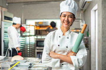 Smiling  asian young female bakers looking at camera..Chefs  baker in a chef dress and hat, cooking...