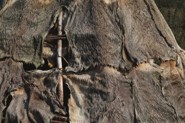 A close-up of a tent made of animal hides and branches  © RMMPPhotography