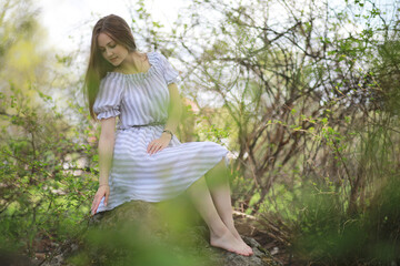 Naklejka na ściany i meble A girl in a spring green park