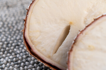 Cassava yucca root with crack close up on rustic rough jute. Sliced raw manioc