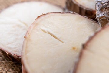 Yucca cassava sliced root close up on rustic rough burlap. Macro