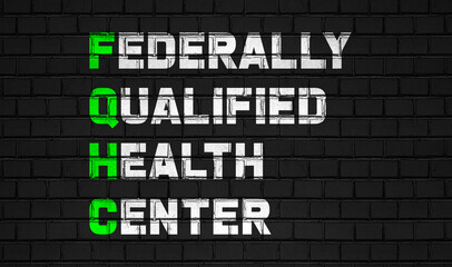 Fototapeta na wymiar federally qualified health center (FQHC) concept,healthcare abbreviations on black wall