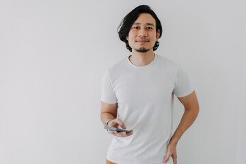 Happy Asian man using smartphone on white background and copy space.