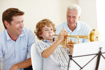 Musical talent runs in this family. Shot of a cute little boy playing the trumpet while his father...