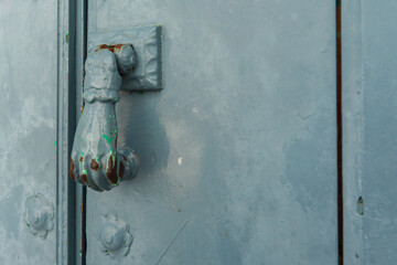 Door with brass knocker in the shape of a hand, beautiful entrance to the house
