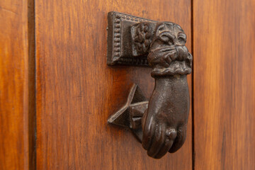 Door with brass knocker in the shape of a hand, beautiful entrance to the house