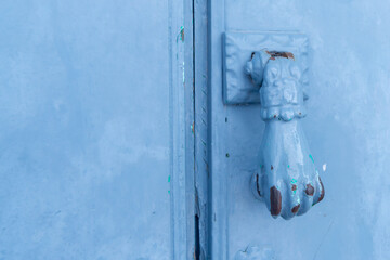 Door with brass knocker in the shape of a hand, beautiful entrance to the house