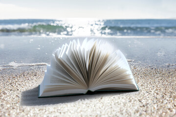 Buch am Strand mit Meer im Hintergrund