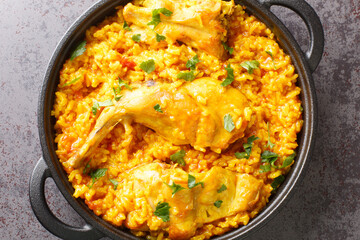 Traditional spanish rice recipe with rabbit close-up in a frying pan on the table. horizontal top view from above