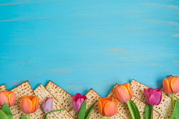 Passover border frame  background. with matzah and tulip flowers over blue table.  Top view, flat...
