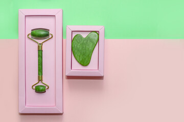 Set of gouache scraper and jade roller on abstract paper background.
