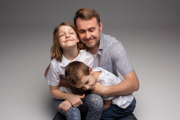 Fototapeta premium portrait of happy father and cheerful son, cute boy playing with dad in the house, child hugging father, dad playing with children, dad hugs daughter