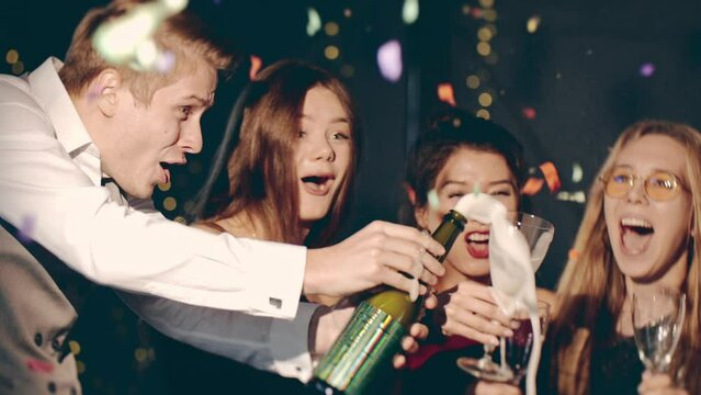 Asian girl and group young college student friends celebrating at glamorous rooftop party ant making toast open and drink champagne at formal social gathering enjoying aning celebration at night