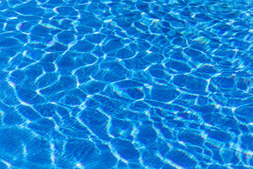 Fototapeta na wymiar Beautiful blue water in a tiled pool reflecting sunlight and glistening