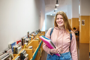 Happy female student in library