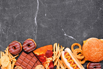 Junk food bottom border over a dark background. Selection of take out and fast foods. Pizza,...
