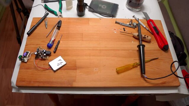 Closeup view of simple electric circuit, breadboard with electrical components, diode, resistors, soldering electrical colored cables and wires. Hand soldering station. Electronic parts