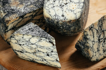 Asiago italian cheese with cuttlefishink on a wooden board. banner, menu, recipe place for text,...