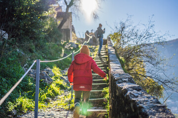 Dad and son travelers in Montenegro in Kotor Old Town Ladder of Kotor Fortress Hiking Trail. Aerial drone view