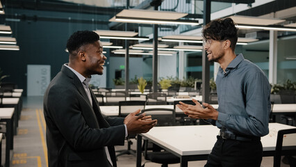 Motivated african arabian business people entrepreneurs colleagues celebrate success negotiation concluding deal with benefit friendly male multiracial winners have fun together enjoying victory dance