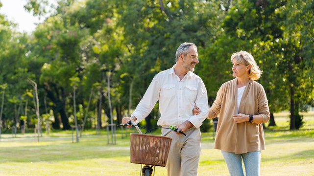 Senior Caucasian couple hugging in park. Family with a happy smile feels relaxed with nature in the morning. Or in the evening. Enter elderly society And retire from work. Concept health insurance