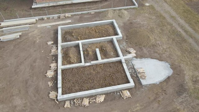 Top down aerial view of building works of new house concrete foundation on construction site