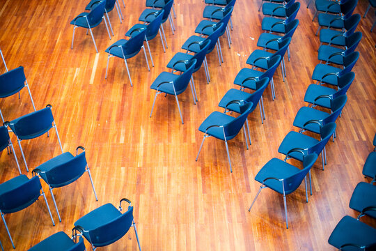 Leere St&uuml;hle in Halle ohne Publikum mit Parkettboden