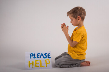 child prayer for the lives of relatives of Ukraine.  Children's asking for help. Save Ukraine. Boy...