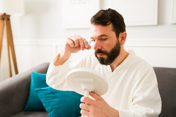 Handsome man removing facial hair