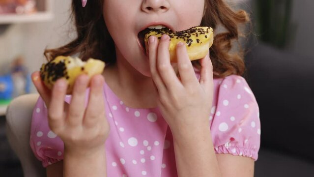Close up of female mouth eating vegan doughnut with chocolate banana icing. Woman is eating two donuts at the same time. Sweet addiction concept