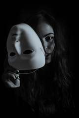 Be authentic and true concept - Black and white portrait of a beautiful young woman with long hair taking off her mask