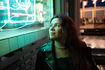 Cinematic night portrait of girl and neon lights in city with copy space - night life and youth...