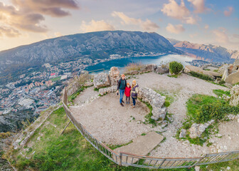 Fototapeta na wymiar Family of hikers on Hiking in Kotor Old Town Ladder of Kotor Fortress Hiking Trail. Aerial drone view