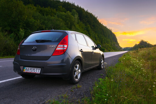 abranka, ukraine - AUG 08, 2020: hatchback on the roadside of mountain pass. wonderful countryside scenery at dawn. glowing clouds on the sky in summertime