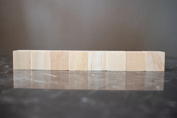 Tower of four wooden cubes on neutral background with copy space