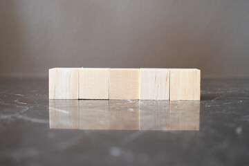 Tower of four wooden cubes on neutral background with copy space