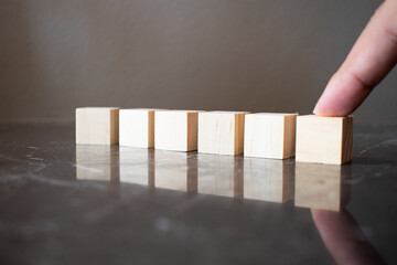 Tower of four wooden cubes on neutral background with copy space
