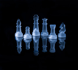 chess pieces on a black reflective surface