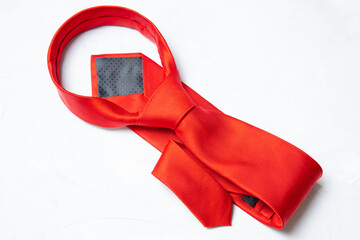 Tied red necktie on a concrete background - obrazy, fototapety, plakaty