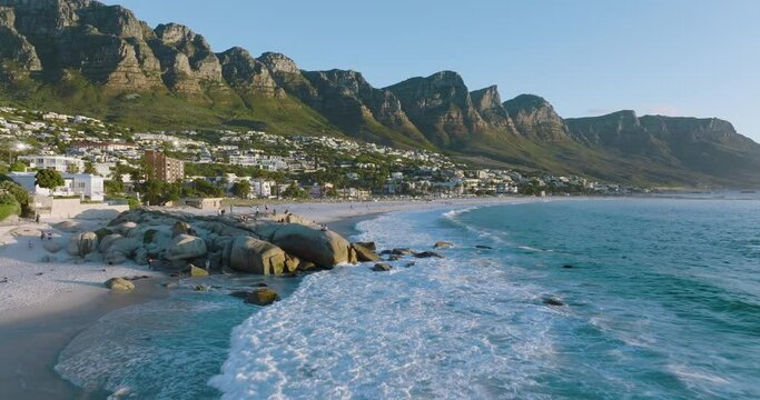 Epic aerial close-up panning view of Camps Bay beach,Lion's Head and 12 Apostles mountain range in background,Cape Town, South Africa