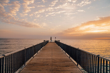 Fototapeta na wymiar Beautiful sunrise over the ocean with a footbridge in Makadi Bay, Egypt