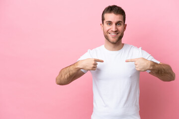 Young caucasian man isolated on pink background with surprise facial expression