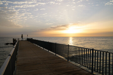 Fototapeta na wymiar Beautiful sunrise over the ocean with a footbridge in Makadi Bay, Egypt