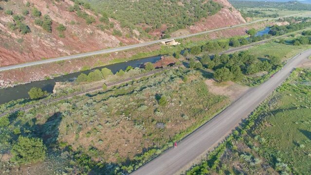 Woman runs on a road in a canyon beside a river