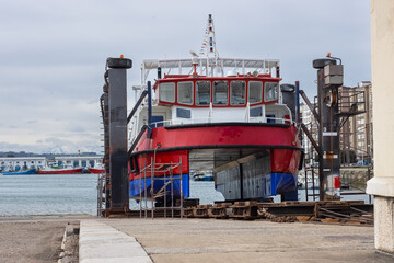 catamar&aacute;n comercial en dique seco siendo pintado y reparado en labores de mantenimiento