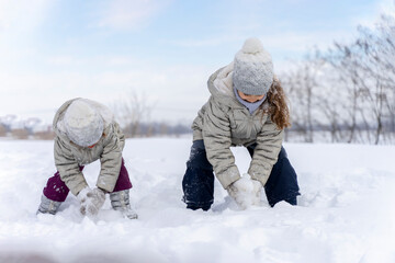 Happy children play snowballs, run, throw snow. Funny kids play games indoors in the winter with snow