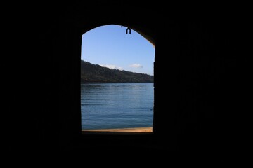 Window of a castle looking to the sea and the montains.