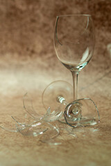 Two broken wine glasses on a light sand background 3